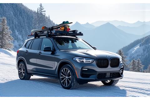 Car with a ski and snowboard rack, loaded with winter sports equipment, against a snowy backdrop.